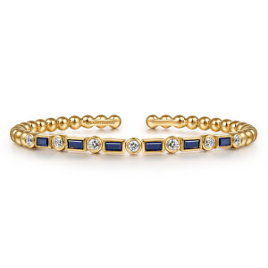 Gabriel & Co. BG5087-6Y45SA 14 karat yellow gold Bujukan bangle, front view of the line of blue baguettes and round diamonds, each in its own bezel