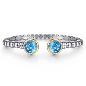 Gabriel & Co. BG5146-57MZJBT sterling silver and 14 karat yellow gold Bujukan bangle, front view of two round blue checkerboard faceted stones in warm bezels facing across the gap