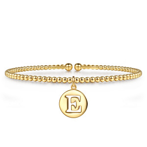 Gabriel & Co. BG5340E-57Y4JJJ 14 karat yellow gold Bujukan bangle, front view of a beaded open cuff with a round disc charm cut with the letter E