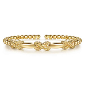 Gabriel & Co. BG5358-57Y4JJJ 14 karat yellow gold Bujukan bangle, front view of the granulated X crossings between smooth tapered bars and the open bead ends