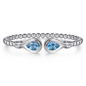 Gabriel & Co. BG5493-57SVJBT sterling silver Bujukan bangle, front view of both pear-shaped blue stones in their rimmed frames facing across the gap
