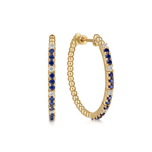 Gabriel & Co. EG15036Y45SA 14 karat yellow gold Bujukan earrings, front view of the pair, one hoop edge on showing runs of blue stones between diamonds