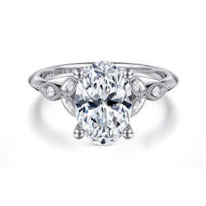 Gabriel & Co. ER11747O8W44JJ 14 karat white gold Victorian engagement ring, front view of an oval center with ball tipped prongs and leaf frames on both shoulders