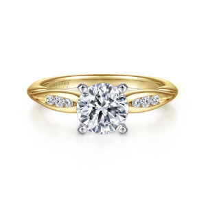 Gabriel & Co. ER11749R4M44JJ 14 karat white and yellow gold Contemporary engagement ring, front view of a round center in four pointed prongs flanked by tapered shoulders set with small diamonds