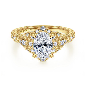 Gabriel & Co. ER12579O4Y44JJ 14 karat yellow gold Victorian engagement ring, front view of an oval center inside a halo of small diamonds with leaf shaped milgrain frames