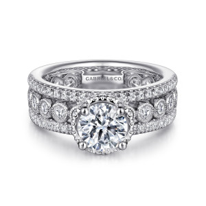 Gabriel & Co. ER14073R4W44JJ 14 karat white gold Contemporary engagement ring, front view of a wide three row band with bead rimmed bezel stones beside the raised head
