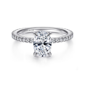 Gabriel & Co. ER14914O4PT4JJ platinum Classic engagement ring, front view of the oval center with pointed claw prongs above a fine band of small diamonds