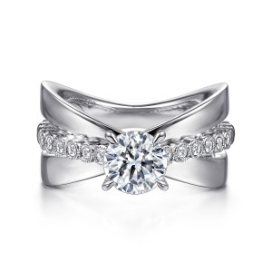 Gabriel & Co. ER15398R4W44JJ 14 karat white gold Contemporary engagement ring, front view of the wide polished arms crossing behind the round center and its bezel set diamond strand
