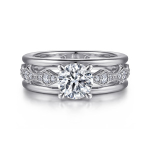 Gabriel & Co. ER15543R4W44JJ 14 karat white gold Contemporary engagement ring, front view of a round center rising from a beaded strip of kite shaped stations between smooth rails