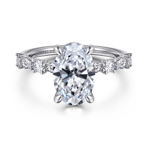 Gabriel & Co. ER15607O10W44JJ 14 karat white gold Contemporary engagement ring, front view of an oval center flanked by alternating round and elongated diamonds on the shoulders