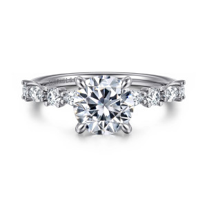 Gabriel & Co. ER15607R6W44JJ 14 karat white gold Contemporary engagement ring, front view of a round center in four prongs flanked by spaced round and elongated diamonds