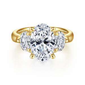 Gabriel & Co. ER15819O12Y44JJ 14 karat yellow gold Classic engagement ring, front view of an oval center with four prongs and a stone tucked against each long side