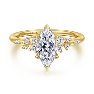 Gabriel & Co. ER15973M4Y44JJ 14 karat yellow gold Starlight engagement ring, front view of a marquise center with pointed tip prongs and scattered small diamonds beside it