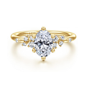Gabriel & Co. ER15973O4Y44JJ 14 karat yellow gold Starlight engagement ring, front view of an oval center with ball tipped prongs and scattered round diamonds on both shoulders