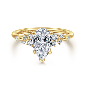 Gabriel & Co. ER15973P6Y44JJ 14 karat yellow gold Starlight engagement ring, front view of a pear shaped center with a pointed tip prong and scattered stones on each shoulder