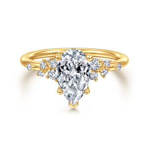 Gabriel & Co. ER15973P6Y84JJ 18 karat yellow gold Starlight engagement ring, front view of a pear shaped center with a pointed tip prong and loose diamond clusters beside it
