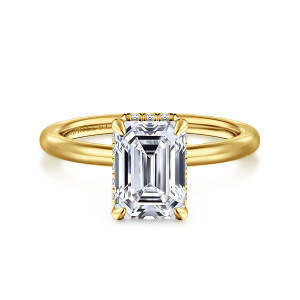Gabriel & Co. ER16061E8Y44JJ 14 karat yellow gold Classic engagement ring, front view of an emerald cut center in slim corner claws with faint diamond glints at its edges