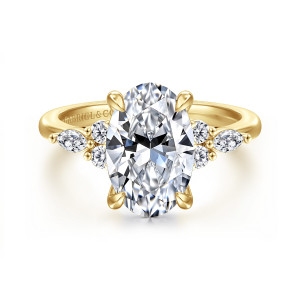 Gabriel & Co. ER16125O12Y44JJ 14 karat yellow gold Contemporary engagement ring, front view of a large oval center with a small diamond cluster on each shoulder