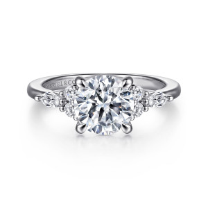 Gabriel & Co. ER16125R6W44JJ 14 karat white gold Contemporary engagement ring, front view of a round center with a small cluster of round and elongated diamonds on each side