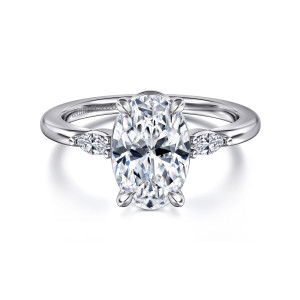 Gabriel & Co. ER16198O8W43JJ 14 karat white gold Classic engagement ring, front view of an oval center between small elongated side stones on a smooth band