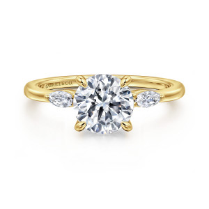 Gabriel & Co. ER16198R6Y43JJ 14 karat yellow gold Classic engagement ring, front view of a round center between two elongated side stones, with a maker's mark inside the band