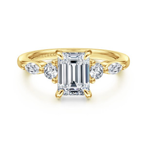 Gabriel & Co. ER16199E6Y44JJ 14 karat yellow gold Contemporary engagement ring, front view of an emerald cut center with a round and an elongated diamond on each side