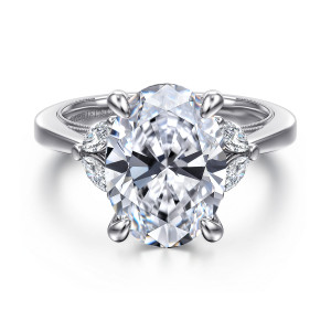 Gabriel & Co. ER16244O18W44JJ 14 karat white gold Contemporary engagement ring, front view of a large oval center with elongated diamonds beside the head and a beaded band edge