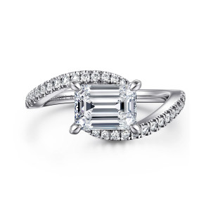 Gabriel & Co. ER16278E6W44JJ 14 karat white gold Contemporary engagement ring, front view of the sideways emerald cut center with diamond lined arms curving past on both sides