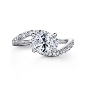 Gabriel & Co. ER16278O6W44JJ 14 karat white gold Contemporary engagement ring, front view of an oval center turned east to west between two pave sweeping bypass ends