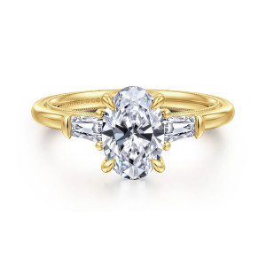 Gabriel & Co. ER16288O6Y44JJ 14 karat yellow gold Classic engagement ring, front view of an oval center with a tapered baguette diamond on each side and claw prongs