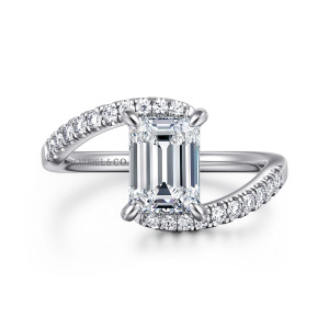 Gabriel & Co. ER16320E6W44JJ 14 karat white gold Contemporary engagement ring, front view of an emerald cut center in four prongs with diamond set arms passing above and below