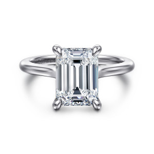 Gabriel & Co. ER16339E12W44JJ 14 karat white gold Classic engagement ring, front view of an emerald cut center with four claws over shoulders that widen toward it