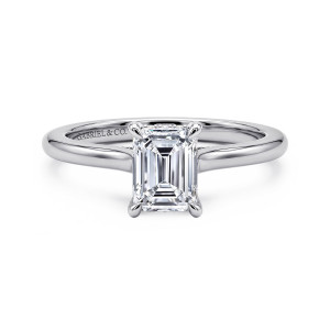Gabriel & Co. ER16339E4W44JJ 14 karat white gold Classic engagement ring, front view of an emerald cut center in four slim claws where curved shoulders rise to the head