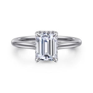 Gabriel & Co. ER16340E6W44JJ 14 karat white gold Classic engagement ring, front view of an emerald cut center with a few small diamonds peeking above the band