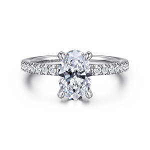 Gabriel & Co. ER16349O6W44JJ 14 karat white gold Classic engagement ring, front view of an oval center in four claws above small round stones set along the band