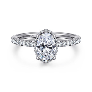 Gabriel & Co. ER16350O4W44JJ 14 karat white gold Contemporary engagement ring, front view of an oval center on four prongs with tiny halo stones peeking out around its edge