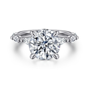 Gabriel & Co. ER16416R12W43JJ 14 karat white gold Contemporary engagement ring, front view of the round center with four claw prongs and elongated diamonds along the band