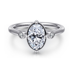 Gabriel & Co. ER16429O6W43JJ 14 karat white gold Contemporary engagement ring, front view of the rimmed oval center with a small bezel set diamond on each shoulder