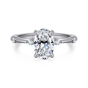 Gabriel & Co. ER16431O6W44JJ 14 karat white gold Contemporary engagement ring, front view of an oval center with round diamonds set apart on each side of a slim band