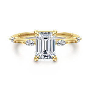 Gabriel & Co. ER16432E6Y43JJ 14 karat yellow gold Starlight engagement ring, front view of an emerald cut center in four claws with elongated stones lying along each shoulder