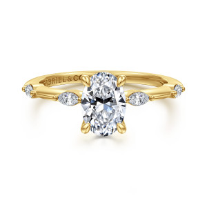 Gabriel & Co. ER16432O4Y43JJ 14 karat yellow gold Starlight engagement ring, front view of an oval center with elongated stones lying lengthwise on either shoulder