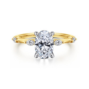 Gabriel & Co. ER16432O6M43JJ 14 karat white and yellow gold Starlight engagement ring, front view of an oval center in rounded prongs with elongated diamonds spaced along a slim band