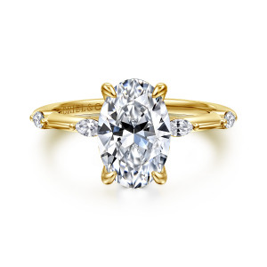 Gabriel & Co. ER16432O8Y43JJ 14 karat yellow gold Starlight engagement ring, front view of an oval center with pointed elongated diamonds spaced along the band
