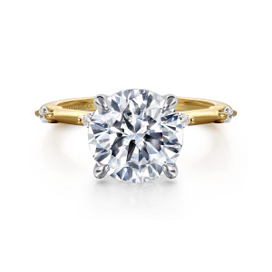 Gabriel & Co. ER16432R12M43JJ 14 karat white and yellow gold Starlight engagement ring, front view of a round center in rounded claws, with small elongated diamonds and beads along the band