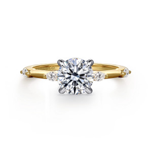 Gabriel & Co. ER16432R4M43JJ 14 karat white and yellow gold Starlight engagement ring, front view of a round center in claws flanked by spaced elongated stones along the band