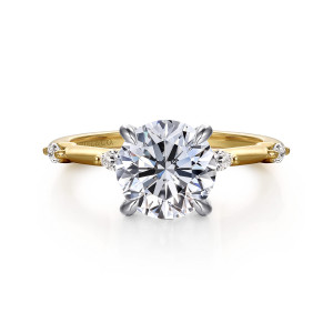 Gabriel & Co. ER16432R8M43JJ 14 karat white and yellow gold Starlight engagement ring, front view of a round center in four claw prongs between elongated diamonds on the band