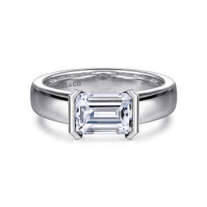 Gabriel & Co. ER16433E6W4JJJ 14 karat white gold Contemporary engagement ring, front view of the emerald cut center held between two flat end walls on a wide band