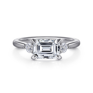 Gabriel & Co. ER16435E6W44JJ 14 karat white gold Lotus engagement ring, front view of a sideways emerald cut center flanked by round diamonds and four tapered claws
