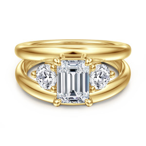 Gabriel & Co. ER16444E6Y44JJ 14 karat yellow gold Contemporary engagement ring, front view of an emerald cut center flanked by round stones inside a wide split shank