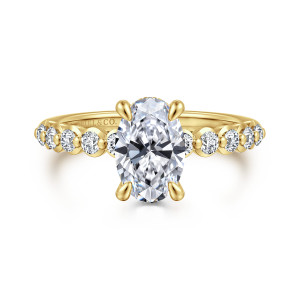 Gabriel & Co. ER16472O6Y44JJ 14 karat yellow gold Contemporary engagement ring, front view of an oval center beside round diamonds in rounded collars separated by tiny beads